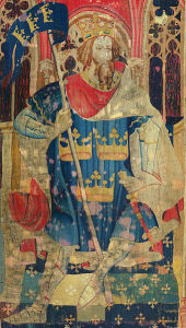 Worn tapestry depicting King Arthur seated on a throne, wearing a crown, cape, and tunic with three crowns on it. He is holding a banner flag on a pole; the flag also has the same three gold crowns on a blue background