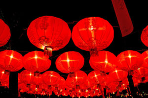 Strings of red round Chinese lanterns against a black night sky