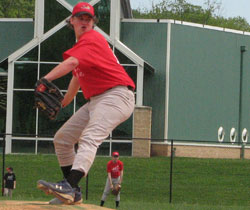 Photo of a teenaged pitcher in mid-throw during a baseball game.