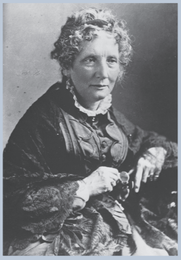Portrait of Harriet Bleecher Stowe as an older woman with curly white hair, black dress and hands held in front of herself