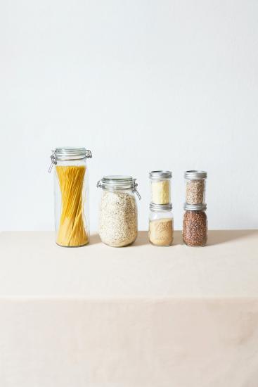 mason jars filled with dry food stuffs including pasta, oatmeal, grains, and coffee