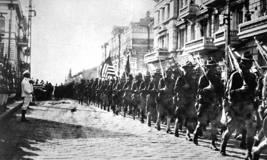 While still fighting in WWI, President Wilson sent American troops to Siberia during the Russian Civil War for reasons both diplomatic and military. This photograph shows American soldiers in Vladivostok parading before the building occupied by the staff of the Czecho-Slovaks (those opposing the Bolsheviks). To the left, Japanese marines stand to attention as the American troops march. Photograph, August 1, 1918. Wikimedia, http://commons.wikimedia.org/wiki/File:American_troops_in_Vladivostok_1918_HD-SN-99-02013.JPEG.