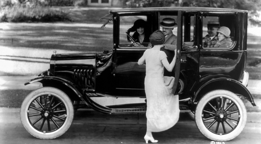 Side view of a Ford sedan with four passengers and a woman getting in on the driver's side, ca.1923. Library of Congress, LC-USZ62-54096.