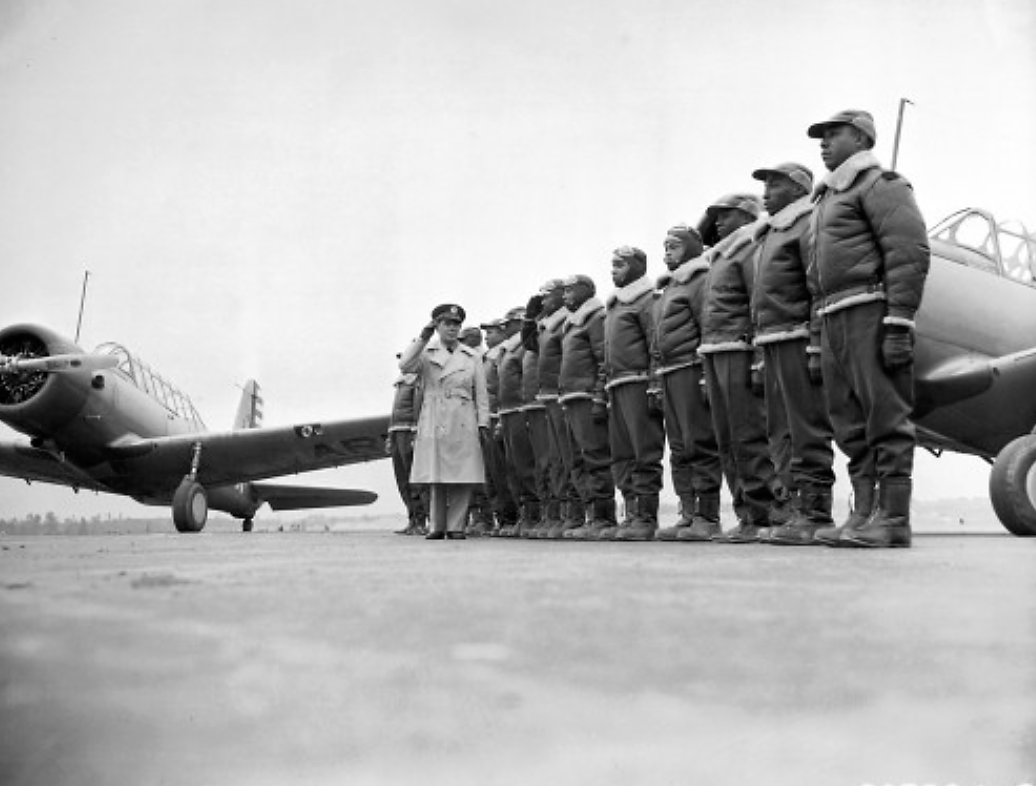 The Tuskegee Airmen stand at attention as Major James A. Ellison returns the salute of Mac Ross, one of the first graduates of the Tuskegee cadets. The photographs shows the pride and poise of the Tuskegee Airmen, who continued a tradition of African Americans honorably serving a country that still considered them second-class citizens. Photograph, 1941. Wikimedia, http://commons.wikimedia.org/wiki/File:First_Tuskeegee_Class.jpg.