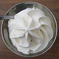 Whipped cream in a tin bowl.