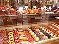 Various pastries displayed under glass in a French patisserie.
