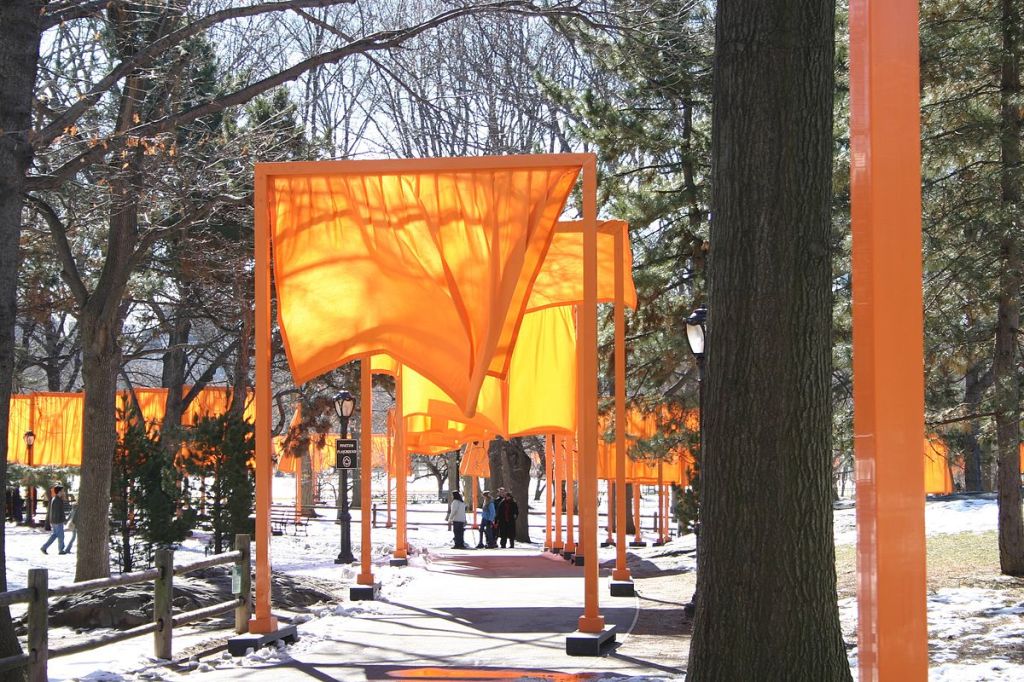 A series of large orange rectangular arches or "gates," lining the paths of Central Park. Each gate has a sheer, orange piece of fabric hanging beneath it.