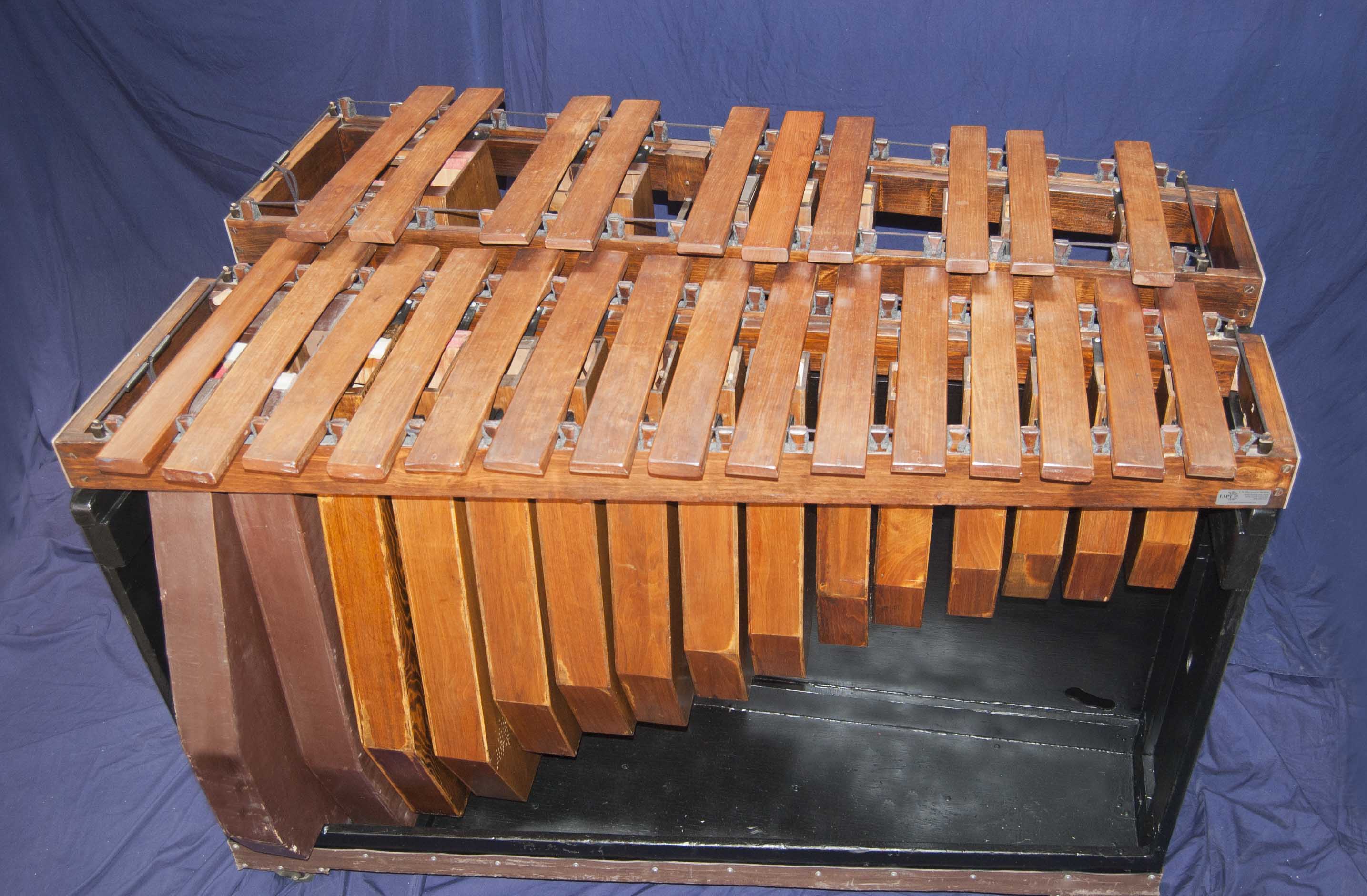 Contra Bass Marimba fabricada en madera con dos niveles, uno para tonos enteros y otro para tonos medios.