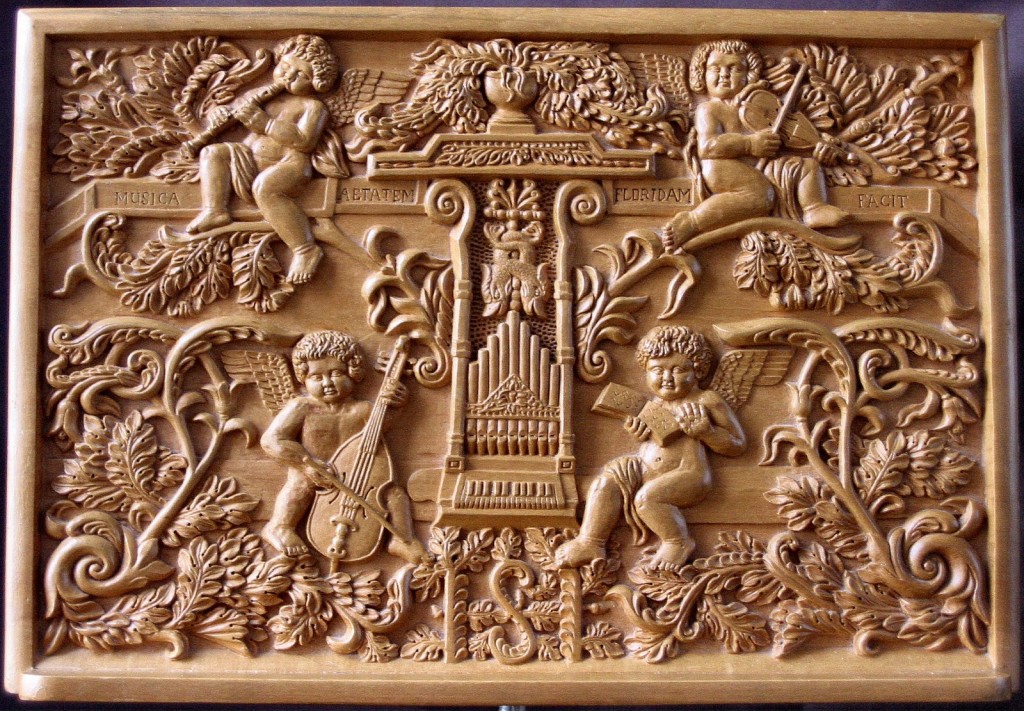 Talla en madera que muestra cuatro ángeles tocando instrumentos: violines, viola da gamba y la flauta dulce