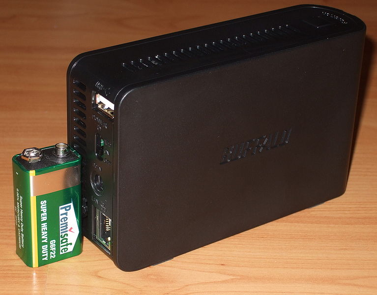 The Buffalo LinkStation Mini with a PP3 battery on the left side. This shows the small size of the NAS with its two 2.5 inch hard disks.