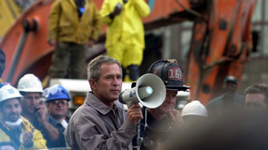 President Bush addresses rescue workers at Ground Zero of the World Trade Center disaster. Thomas R. Roberts, New York, NY, September 14, 2001. Via FEMA Photo Library. 