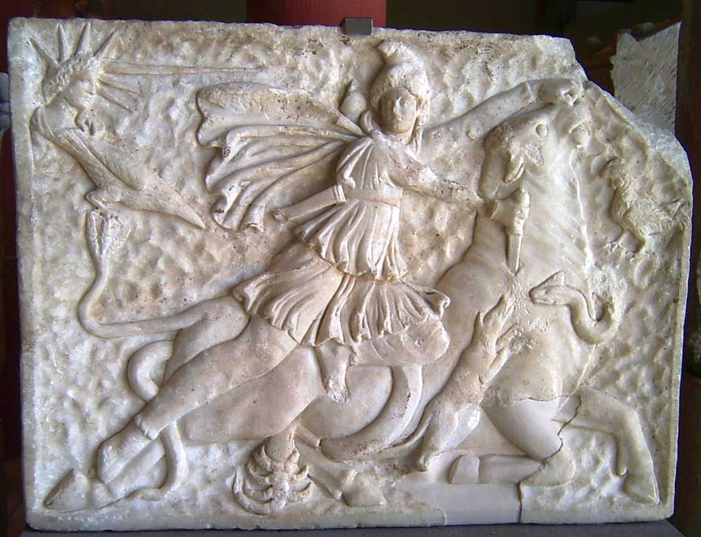 Marble relief illustrating the go Mithra slaying a bull. Stationed around Mithra are other beasts. A scorpion and dog are at the bottom of the relief while a snake intertwines around the bull.