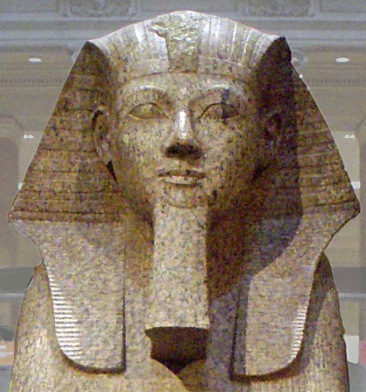 The second picture is also a stone depiction of Hatshepsut. Still expressionless with the royal crown, the queen is now featured with a false beard to connote her pharaonic authority.