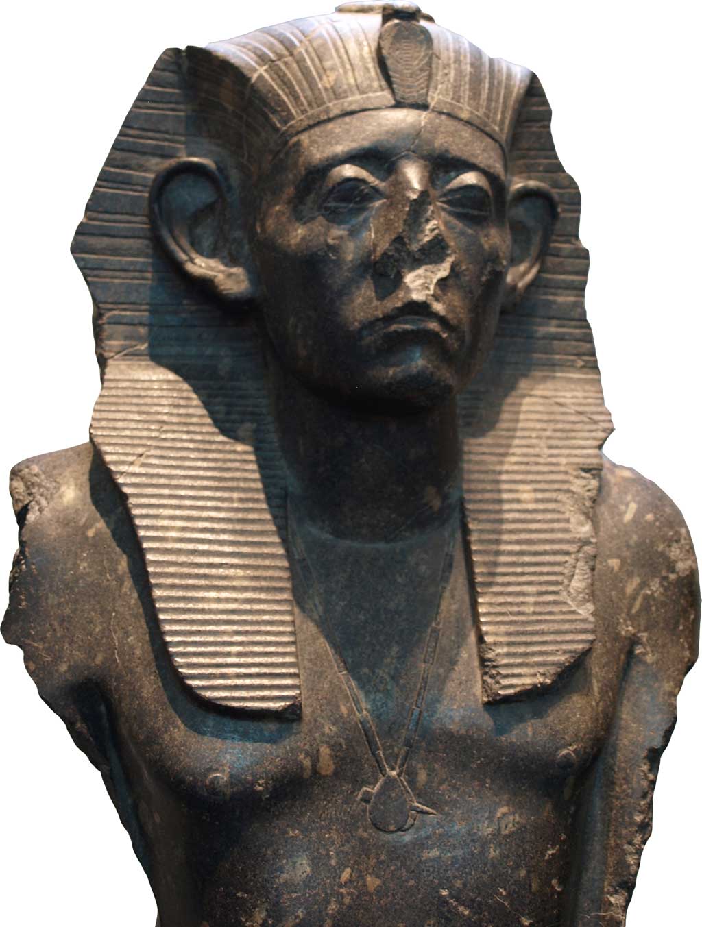 Black sandstone statue of Senusret III wearing the Pharaonic headdress. His nose is missing from the statue, suggesting that it was defaced. His eyes are contemplative and his brow tense, connoting perhaps his recognition of the vicissitudes which have befallen Egypt in prior centuries.