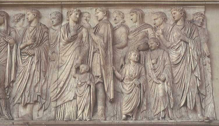 This photo shows a detail from the processional scene on the south wall of the Ara Pacis Augustae. In the center stands Augustus next to his wife Livia. Their family stands behind the couple on all sides. The figures ascend from the wall giving them a three-dimensional quality.