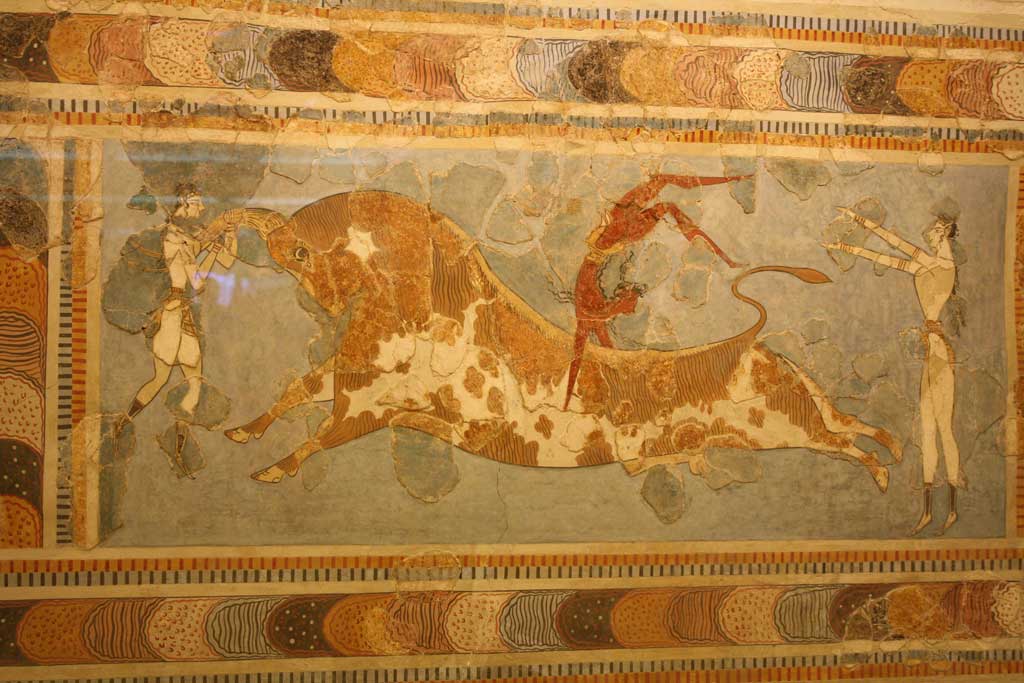 Fresco from Knossos depicting a brown-skinned performer somersaulting over a large bull with the aid of two light-skinned assistants. The fresco may indicate that Knossos was a multi-cultural society.