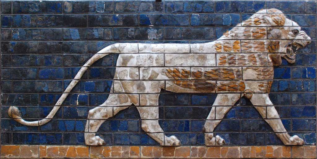 Picture of an ambulating tan lion from the Ishtar Gate. The background behind the lion is deep blue. The image is entirely made of glazed bricks.