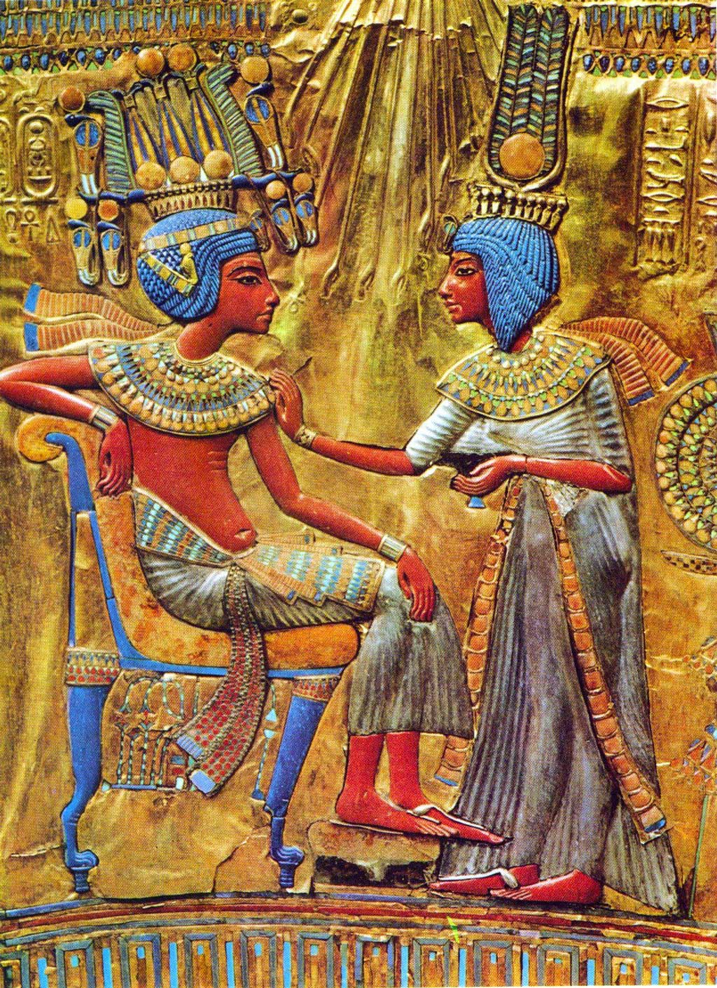 The image comes from the gold-plated throne of Tutankhamun. It depicts the king seated on a couch while his wife, Ankhsenamun, stands before him, touching his shoulder. Both figures are vibrantly colored with umber skin, indigo hair, and grayish-white garments.