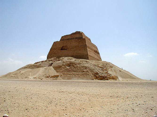 The picture is that of the pyramid of Meidum. Here, a mound of dirt and stone lies around the smooth-sided stone tower within, from which it has rescinded over time.