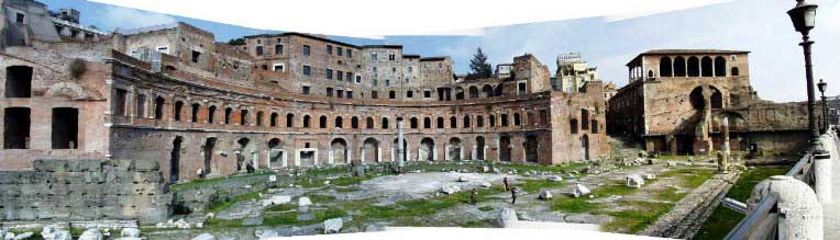Picture of Trajan's Markets as they appear today. In the foreground lay the remains are that of an open courtyard littered with stone ruins. In the background are the remains is a partially spherical two-storied building that once served as the Roman marketplace.