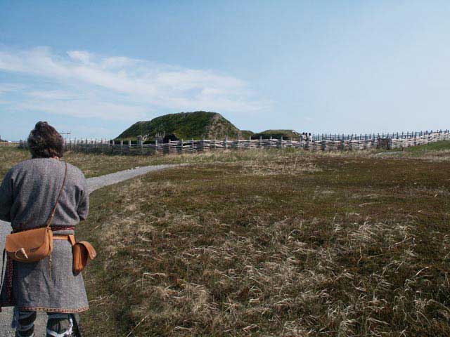 Photograph of a reenactor surveying the Viking colonisation site at L'Anse-aux-Meadows, Newfoundland, Canada