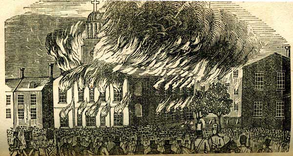 Church in flames with people gathered around