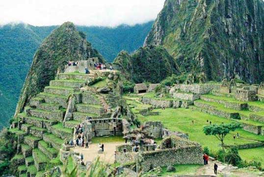 Photograph of the Central Square of Machu Picchu, showing terraces, homes and people.