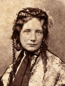 Sepia-toned photo of Harriet Beecher Stowe as a head shot. She is wearing a lace bonnet and looking directly at the camera