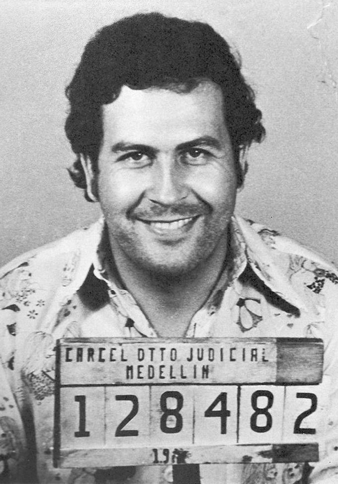 A mugshot of Pablo Escobar, smiling.