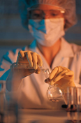 A female chemist pours liquid into a test tube.