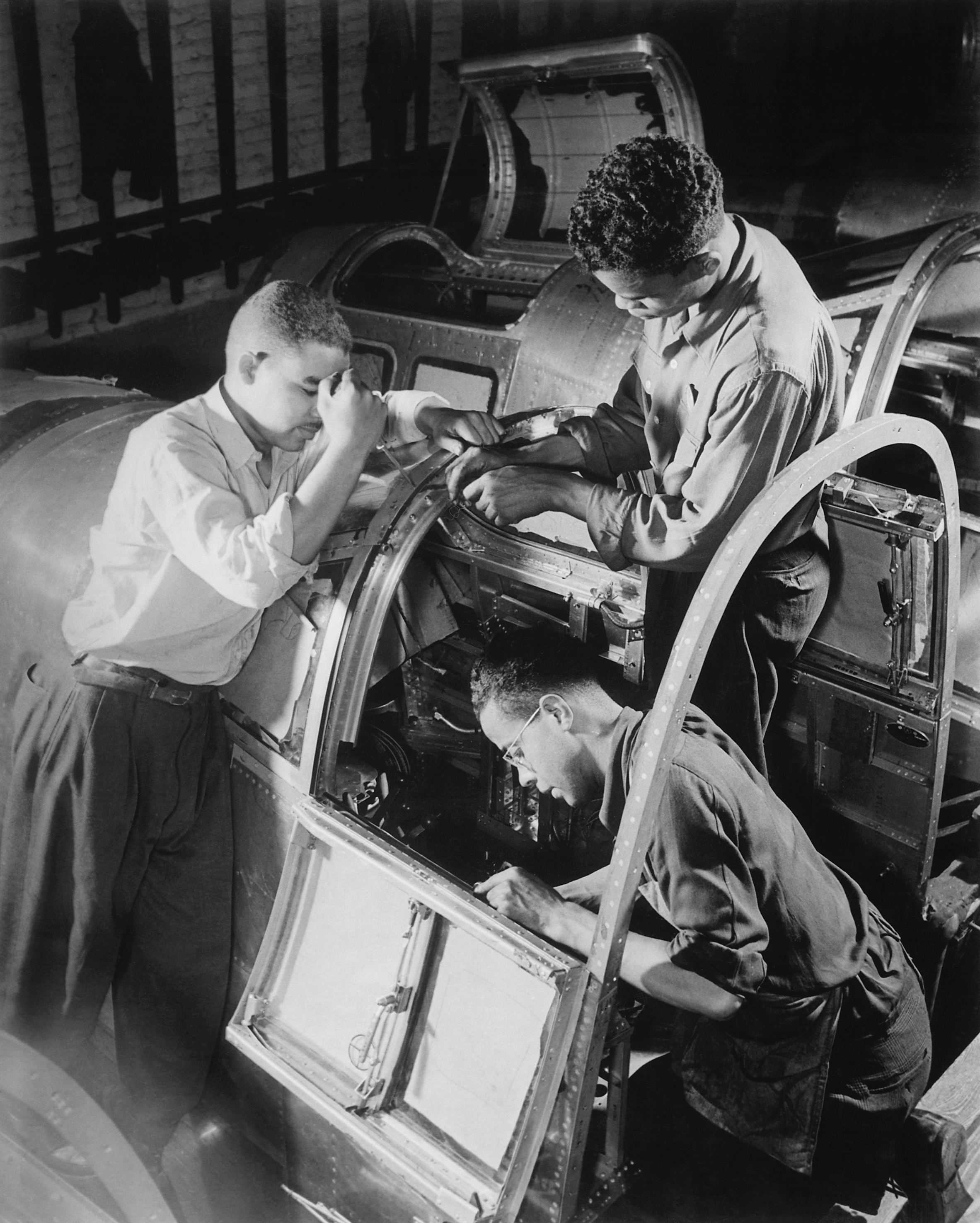 Final_assembly_of_the_pilots_compartment_is_being_made_by_these_Negro_workers_in_a_large_eastern_aircraft_factory._The_-_NARA_-_535810_-_restored.png