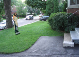 Photo of a woman vacuuming the lawn