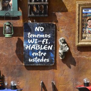 Photo of a sign outside a restaurant that says "No tenemos wi-fi HABLEN entre ustedes"