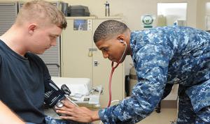 doctor in military uniform taking a mans blood pressure