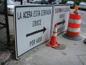 Sign and cones closing a sidewalk.