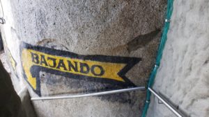 sign pointing down stairs reads: "bajando"