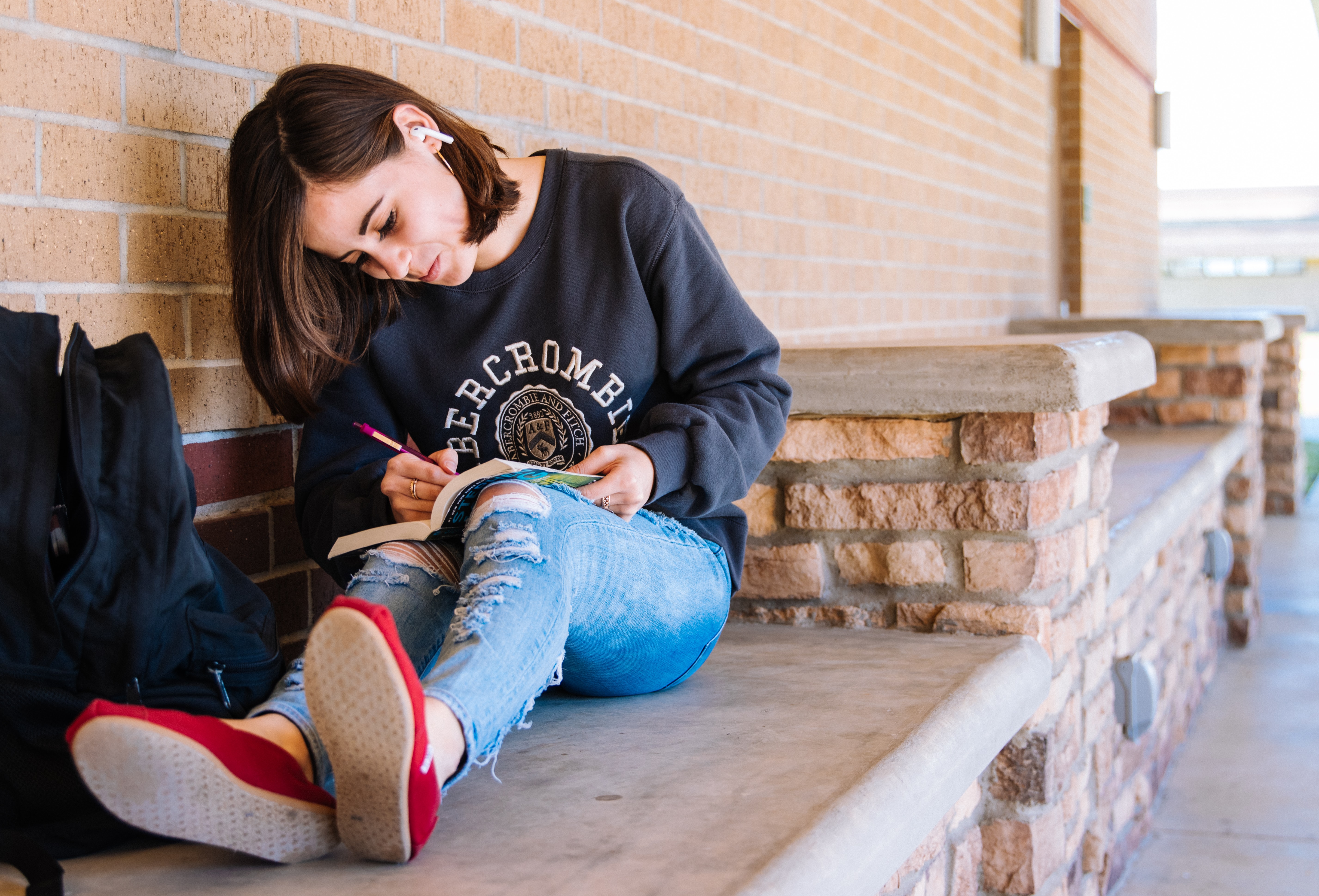 Una joven tomando notas en un libro.