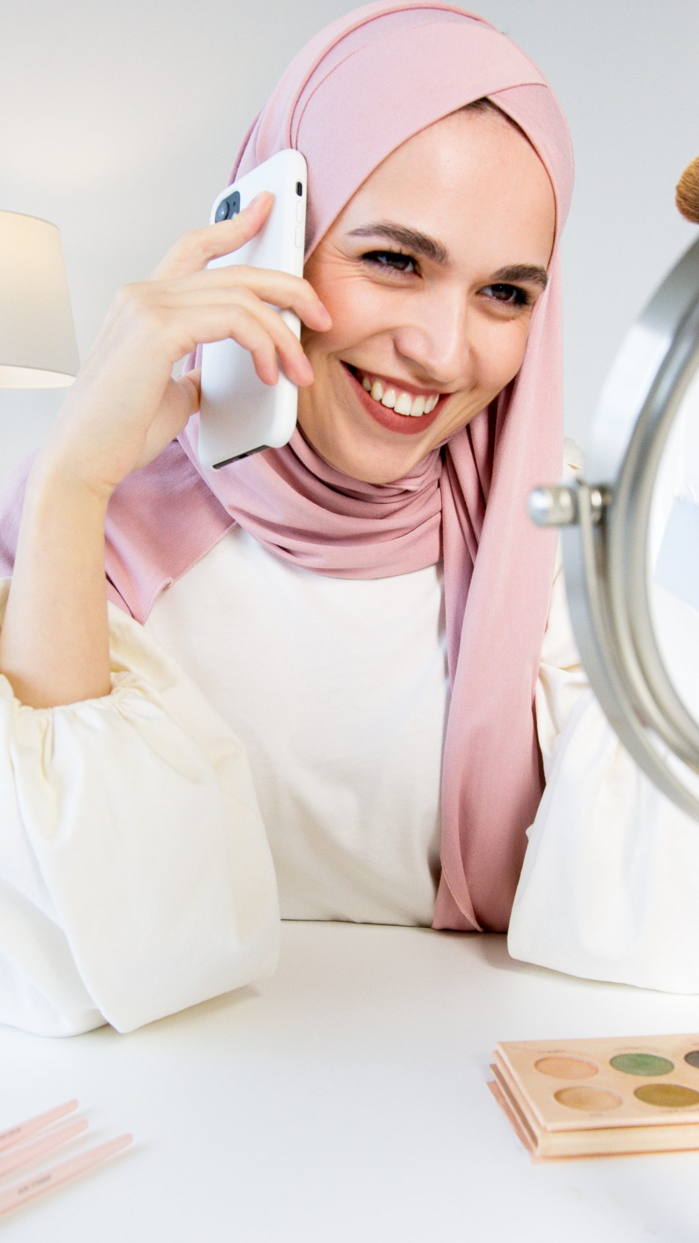woman in pink hijab holding phone