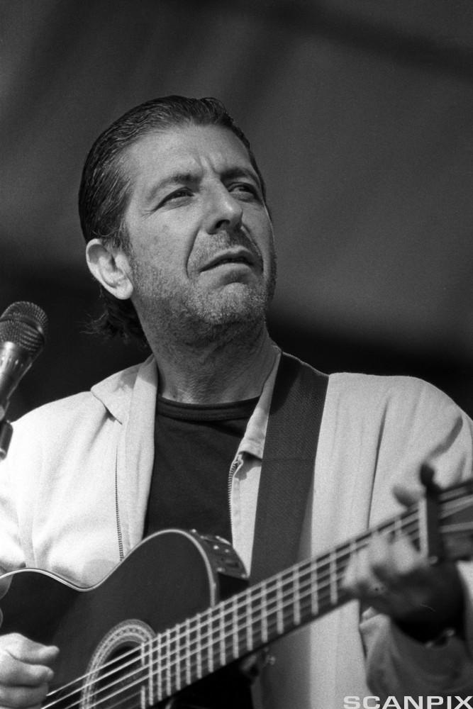 Leonard Cohen sosteniendo una guitarra en blanco y negro