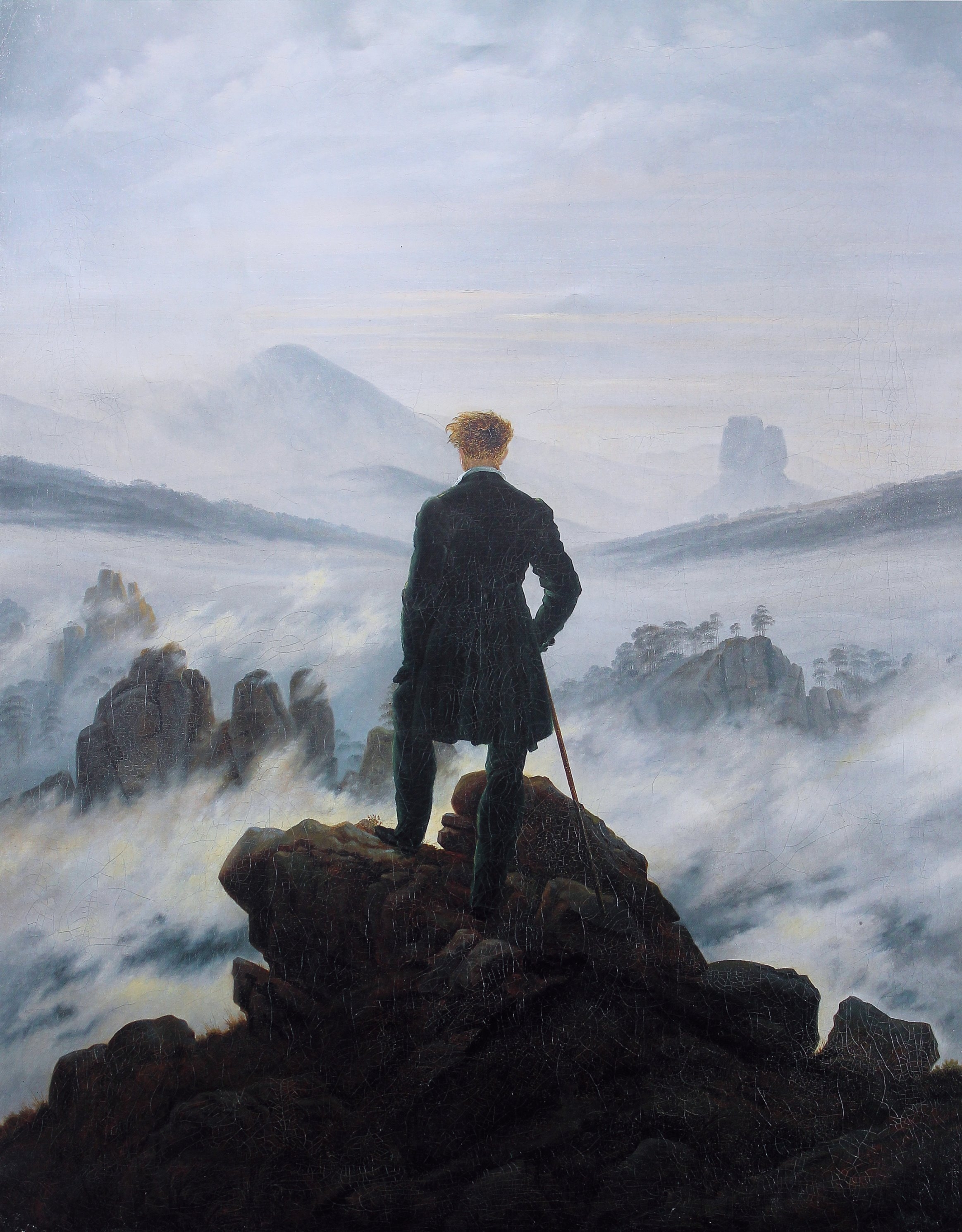 un hombre se para en la cima de una montaña con vista a un mar de nubes