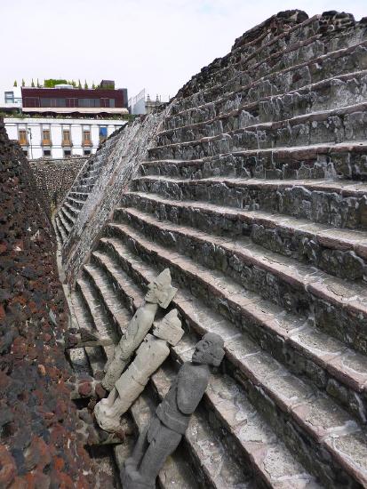 Three sculptures laying on steps of Templo Mayor 