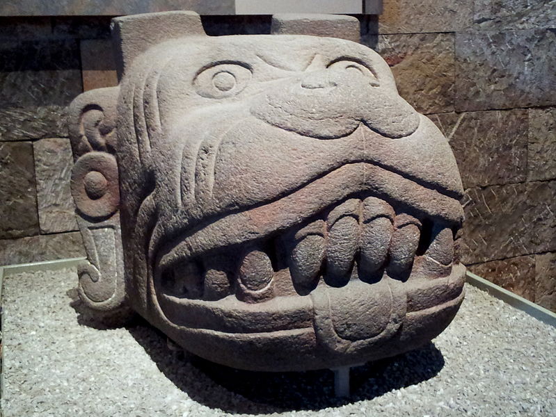 stone carving of a dog with large front teeth