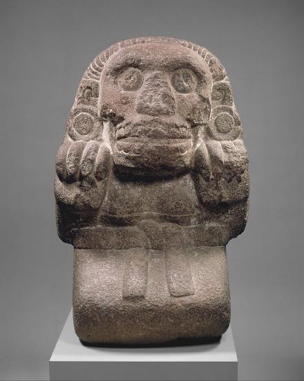 a female stone sculpture sitting with a skirt and belt