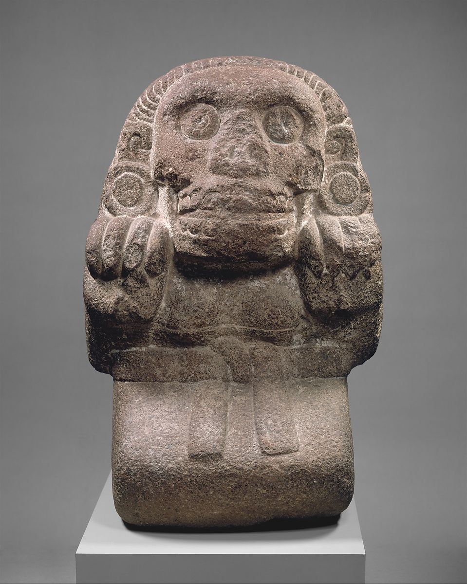 a female stone sculpture sitting with a skirt and belt