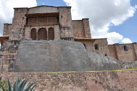 A remnant of an Inkan temple is at the base of a Spanish church