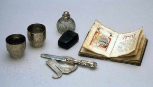 Complete circumcision set, consisting of knife, epamel powderbox and protecting plate. Knifehandle shows Judith with the head of Holophernes in one hand and a sword in the other. This circumcision-set was bought from Mrs. Goitein, widow of the late Rabbi Goitein from Karlsruhe, (Baden, Germany). Mrs. Goitein Pointed out that the circumcision set had come down in her family and that it was used by a member of the family Cagliari, a martyr in Posen who died after having been tortured at the beginning of the 18th cent.