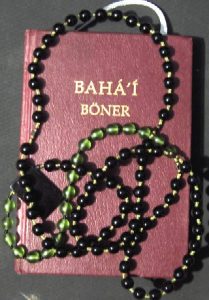 Bahá'í Book of Prayers covered with a Bahá'í chaplet
