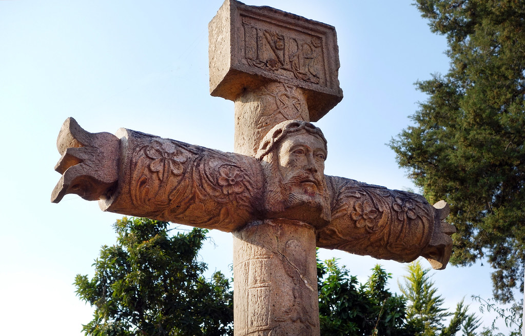 religious cross made of stone and carved with symbols