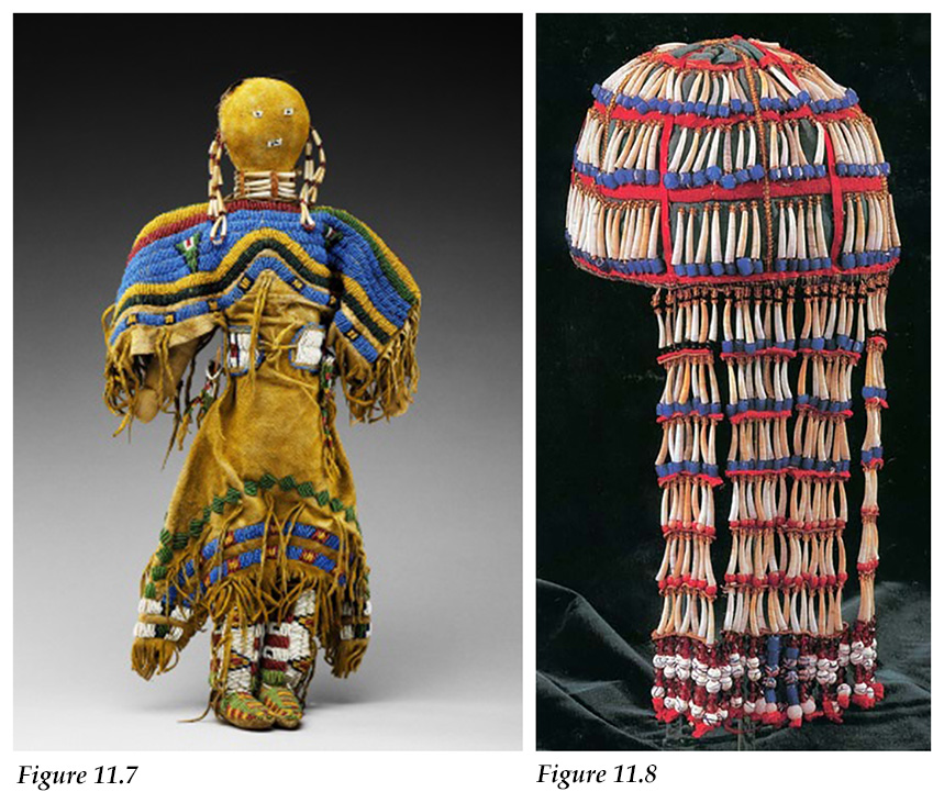 Dentalium shells dangle from the braids and form a necklace for a Sioux doll and beaded Tlingit headdress