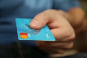 Man's hand holding a debit card